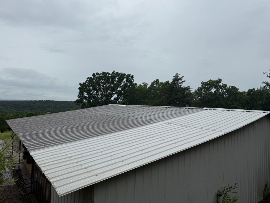 Industrial metal roof restoration project in Arkansas showing restored and existing metal roof sections