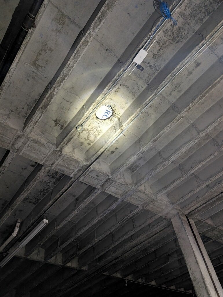 Interior view beneath a commercial roof showing existing structural conditions evaluated before roof restoration
