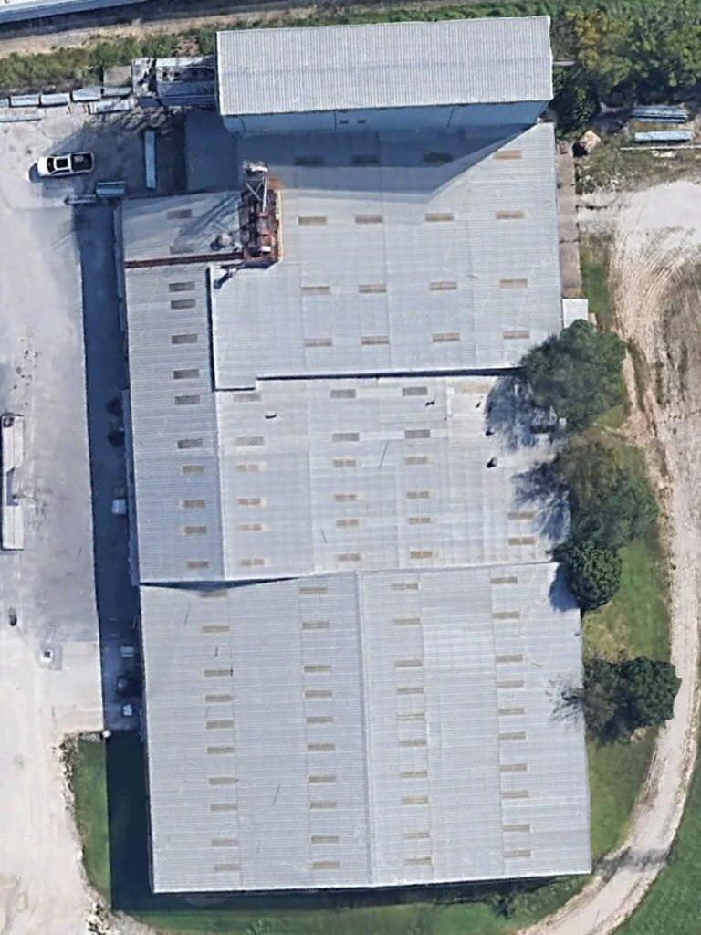 Aerial view of an aging industrial metal roof in Arkansas before commercial roof restoration