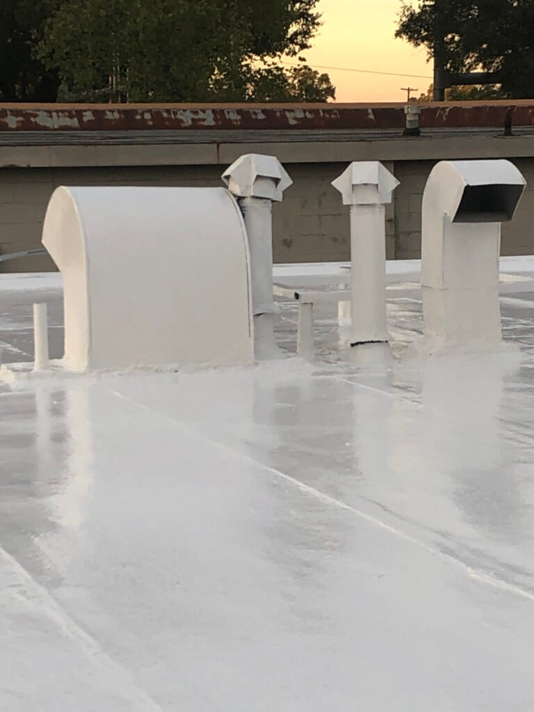 Restored commercial roof penetrations sealed with protective roof coating