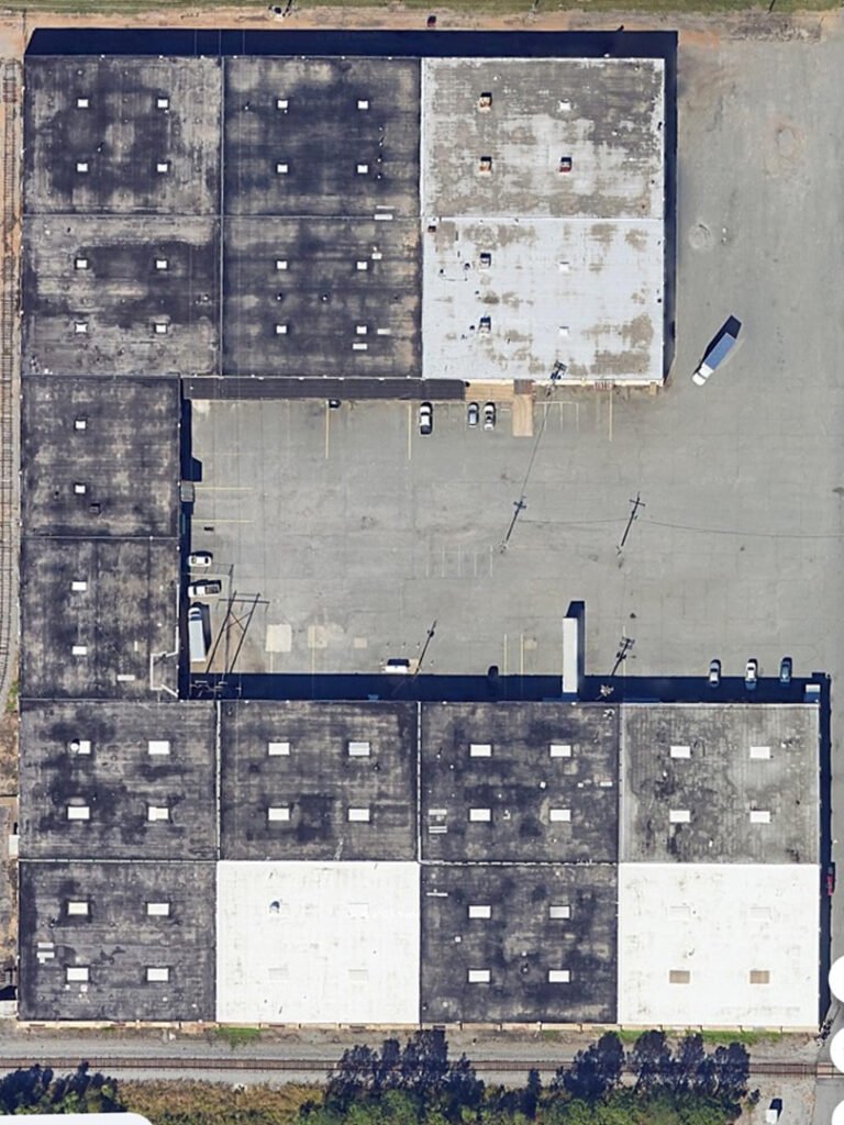 Aerial view of aging commercial roof systems before restoration in Arkansas