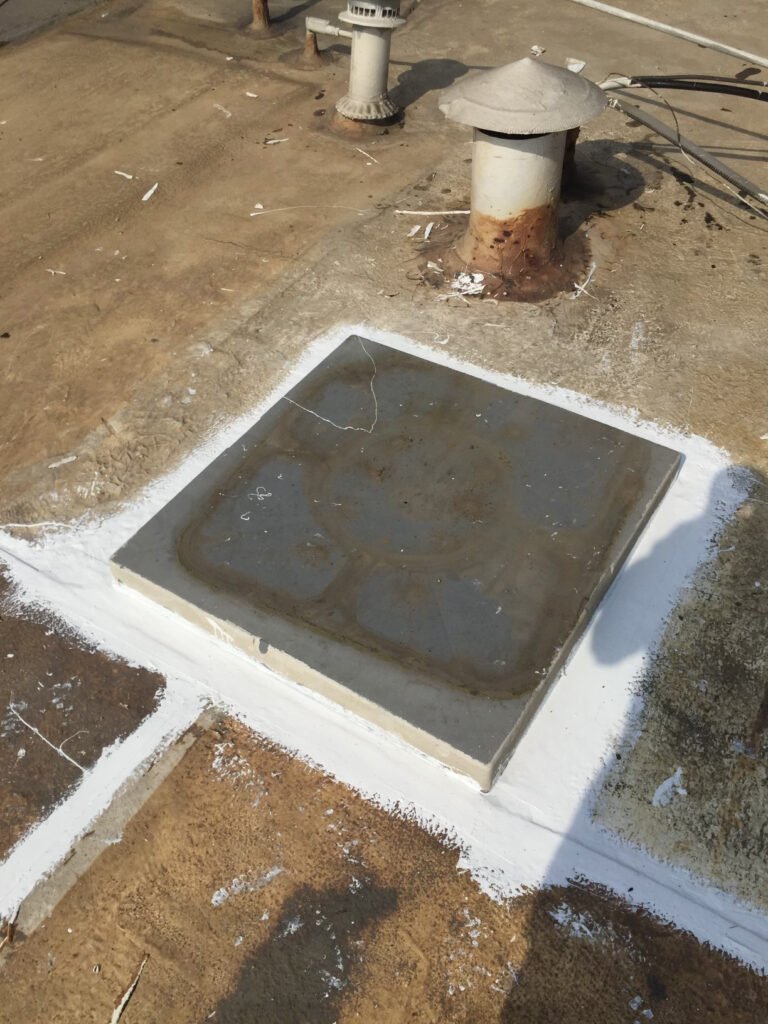 Commercial roof curb and seams being sealed during roof restoration