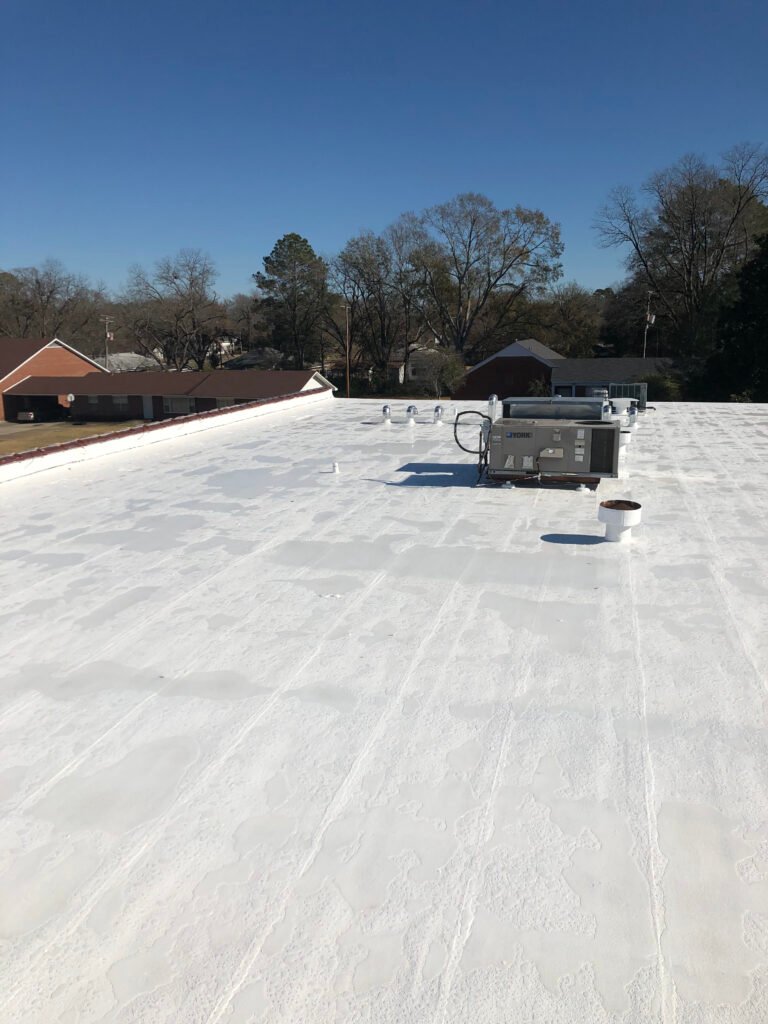 Completed commercial roof restoration with white protective coating in Arkansas