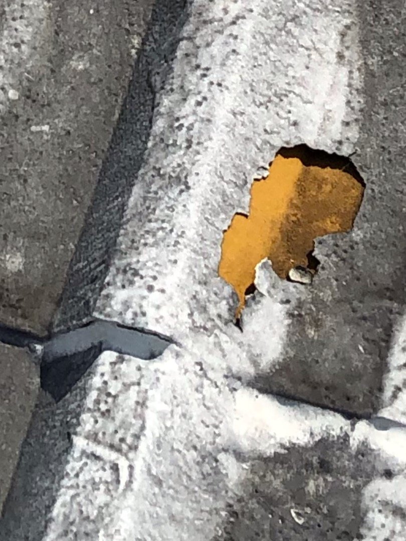 Deteriorated commercial metal roof with exposed corrosion before restoration