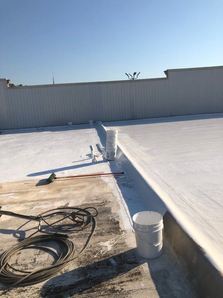 Commercial roof coating being applied during the restoration process