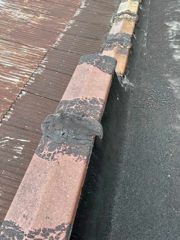 Deteriorated commercial roof flashing and failed waterproofing detail