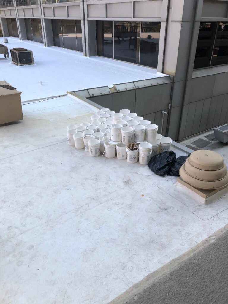 Roof coating materials staged during commercial roof restoration