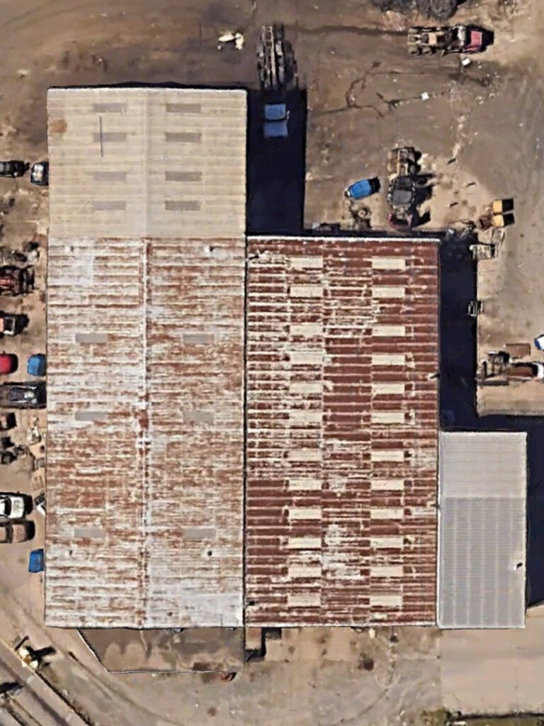 Aerial view of weathered industrial metal roof before commercial roof restoration in Arkansas