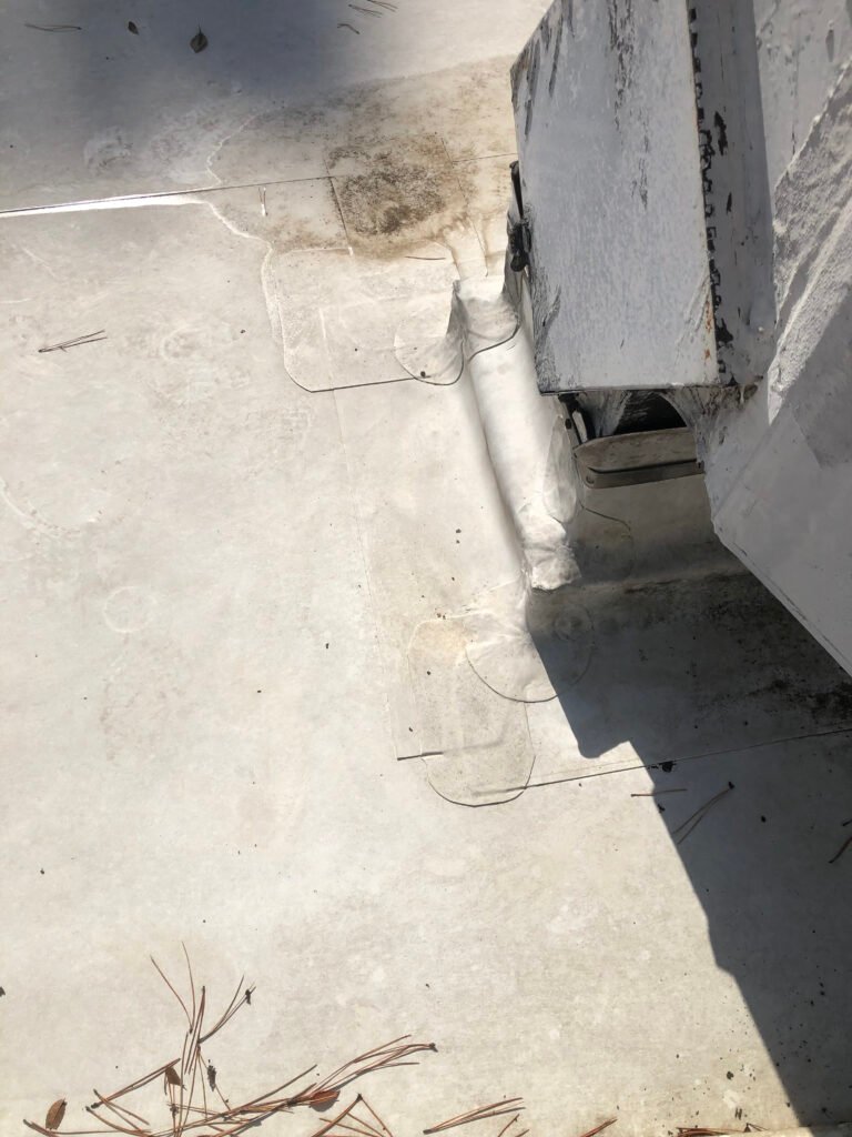 Deteriorated commercial roof flashing around rooftop equipment before restoration