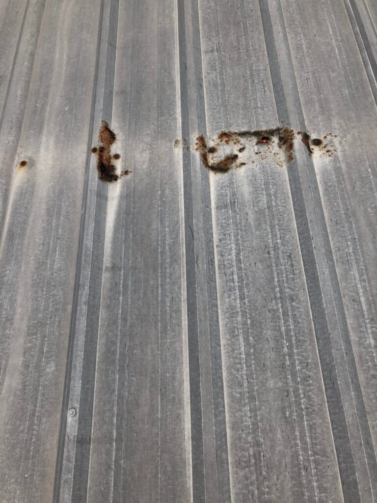 Rust and corrosion around fasteners on commercial metal roof panels