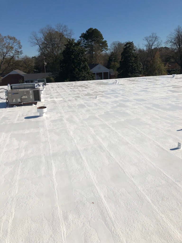 Completed commercial roof restoration with white reflective roof coating in Arkansas